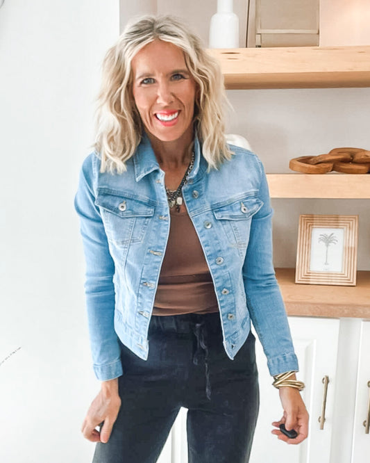 Woman wearing a denim jacket in a kitchen setting