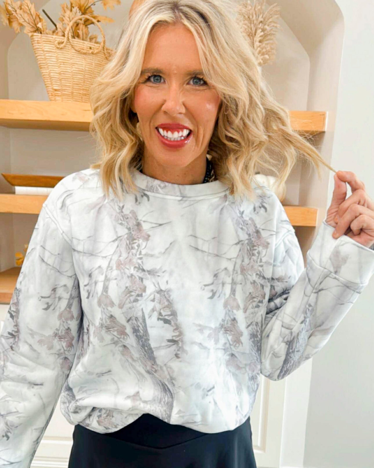 Woman wearing a marble-patterned blouse in a home setting