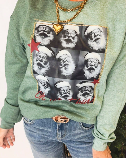 Green sweatshirt with a pattern of Santa Claus faces and a gold chain detail.