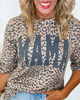 Person wearing a leopard print shirt with 'MAMA' text on a plain background