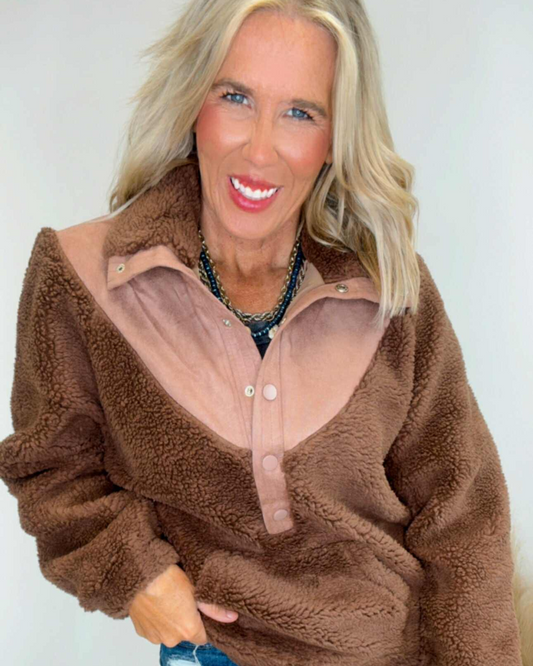 Woman wearing a brown fleece jacket with a white background