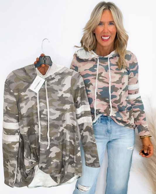 Woman holding a camouflage jacket with a plain white background