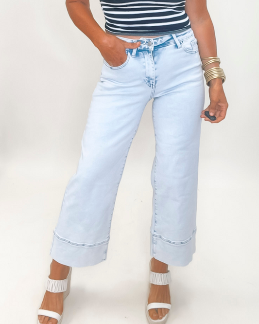 Light blue jeans worn by a person on a plain background