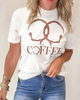 Person wearing a white t-shirt with coffee-themed design and blue jeans.