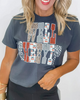 Woman wearing a dark gray t-shirt with colorful graphic design on a plain background