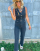 Woman wearing a denim jumpsuit with a metal wall background