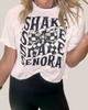 Person wearing a white t-shirt with black text and graphics on a plain background