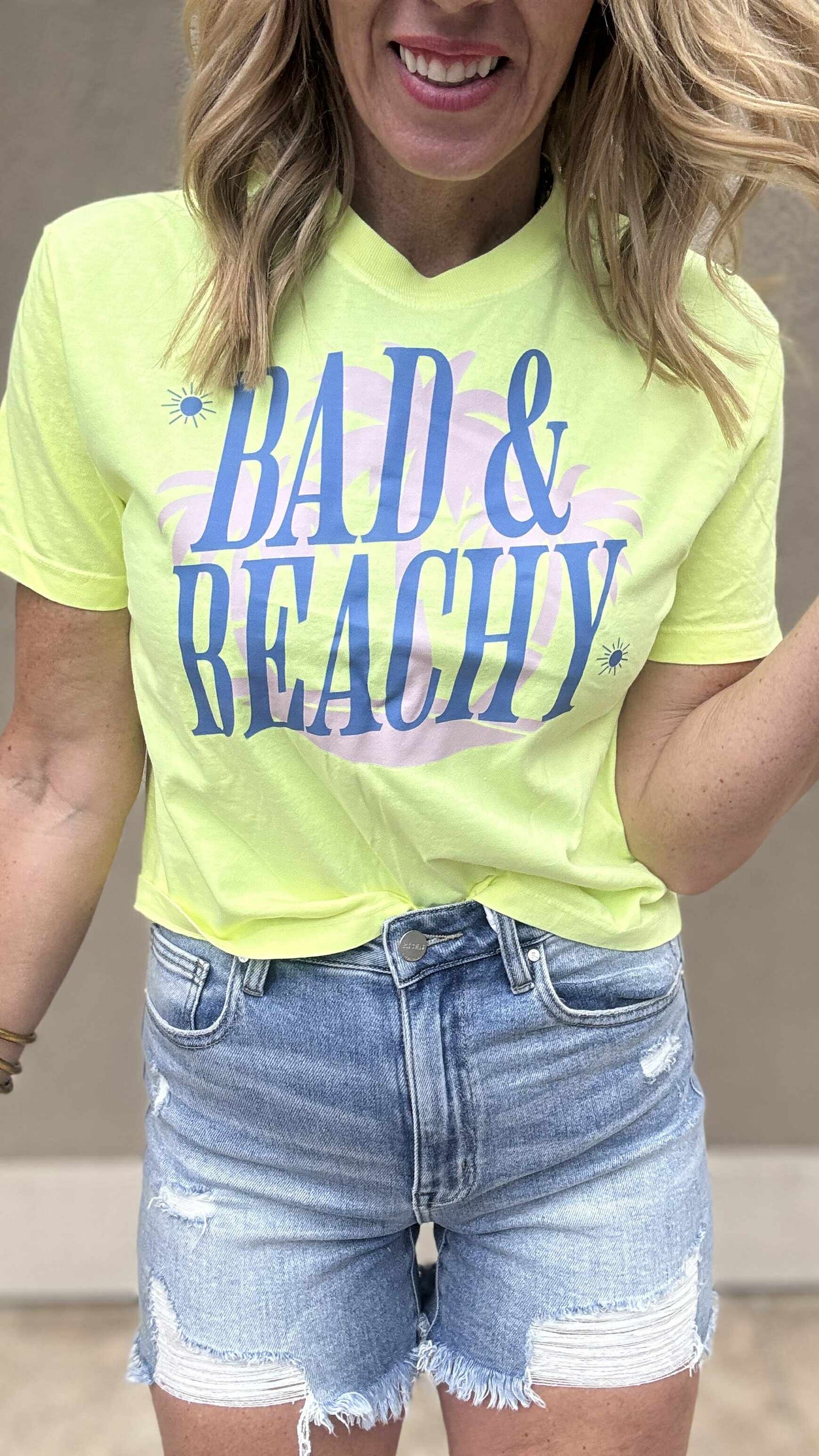 Bad & Beachy boxy crop tee styled with high-rise distressed denim shorts.