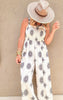 White wide-leg jumpsuit with black boho embroidery and smocked bodice.