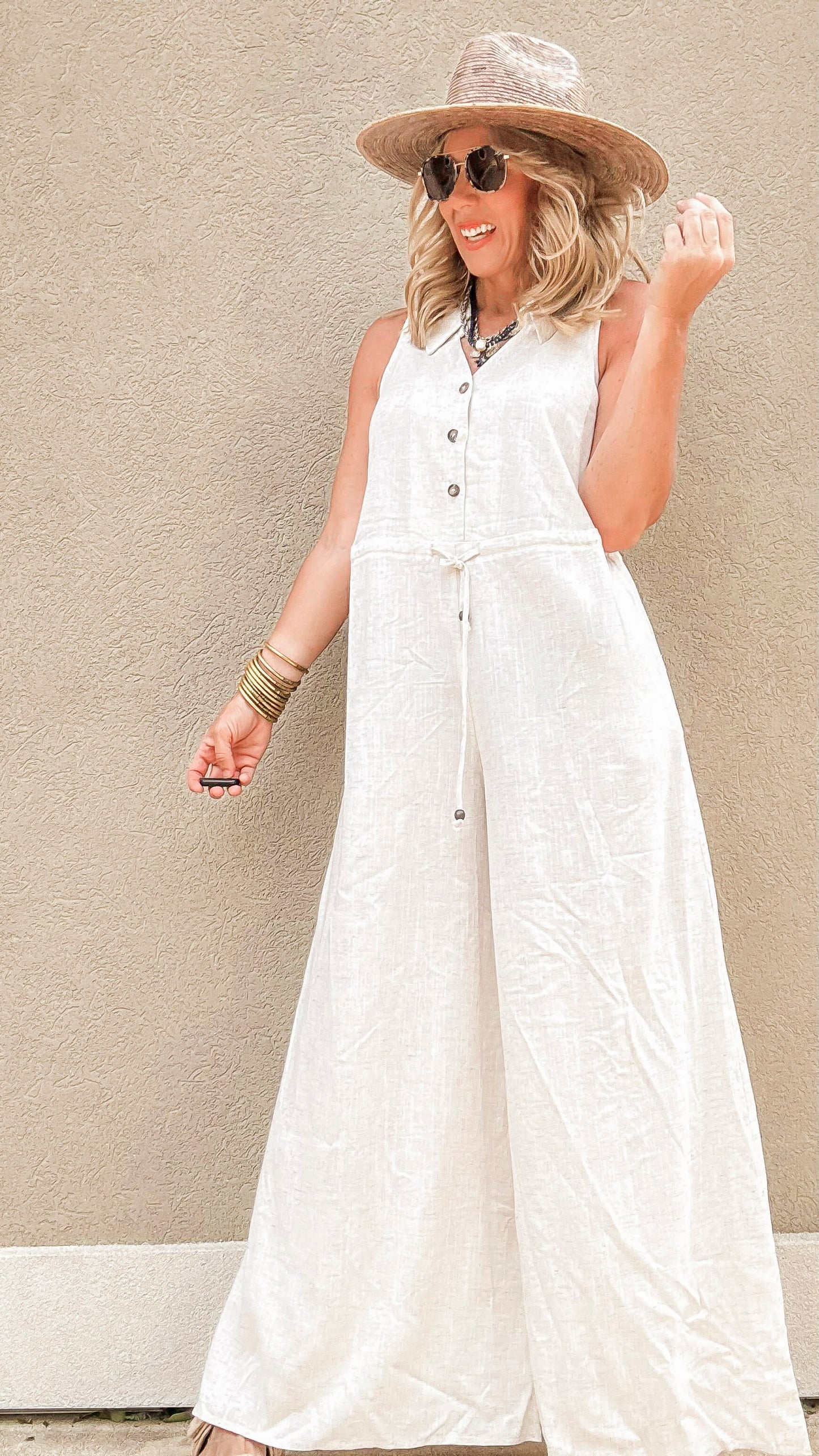 Casual linen-blend wide-leg jumpsuit with front buttons and drawstring waist.
