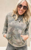 Soft camo sweatshirt featuring front pouch pocket and ribbed cuffs, styled with casual denim.