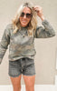 Cozy camo fleece sweatshirt styled casually with black denim cutoffs and layered necklaces.
