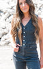 Woman wearing a denim jumpsuit standing against a rocky background