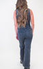 Person wearing a denim jumpsuit on a white background