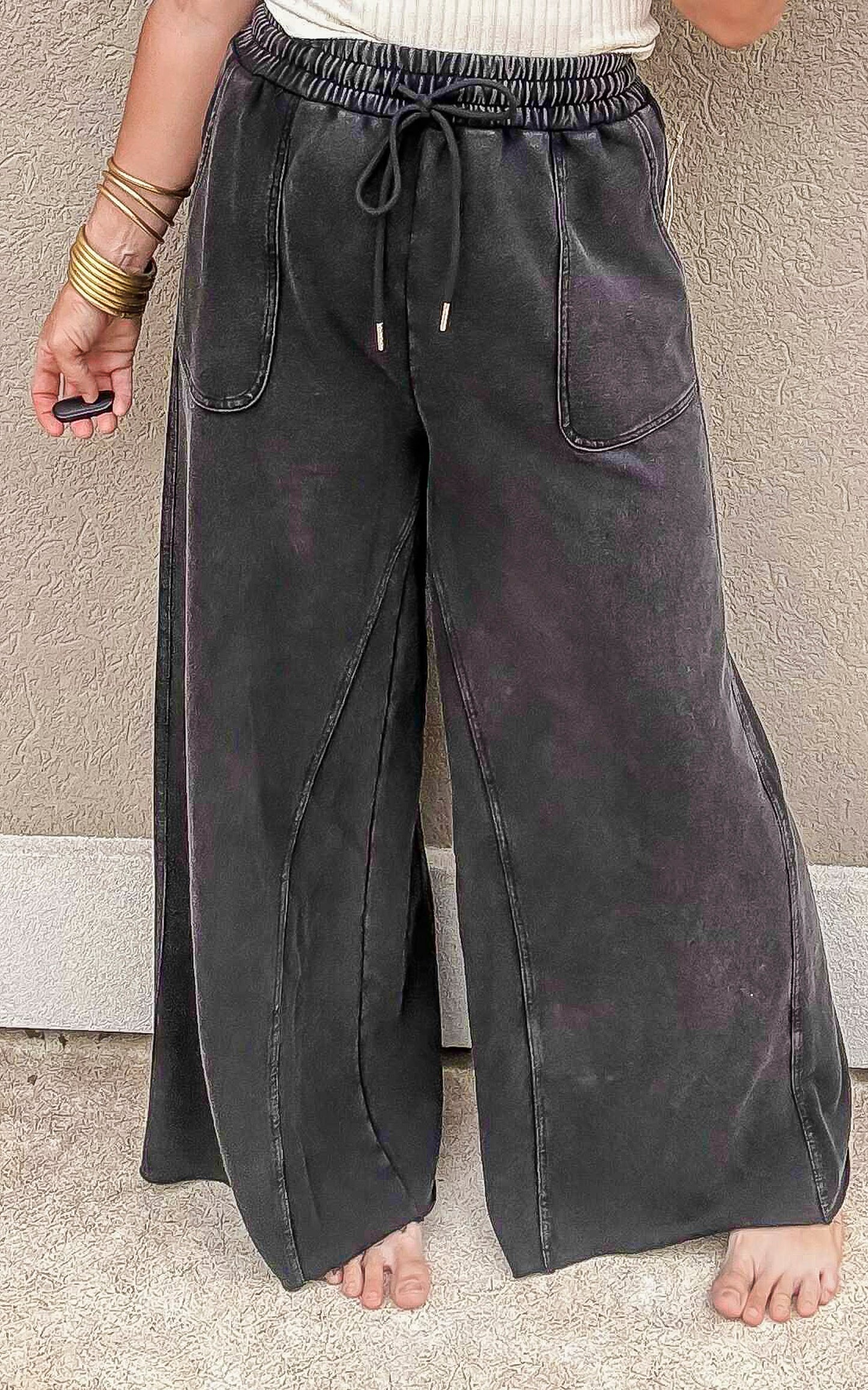 Relaxed fit mineral-washed black pants featuring front seam detail and slouchy pockets.