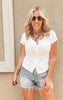 Fitted white short sleeve snap-button top styled with light wash denim shorts.