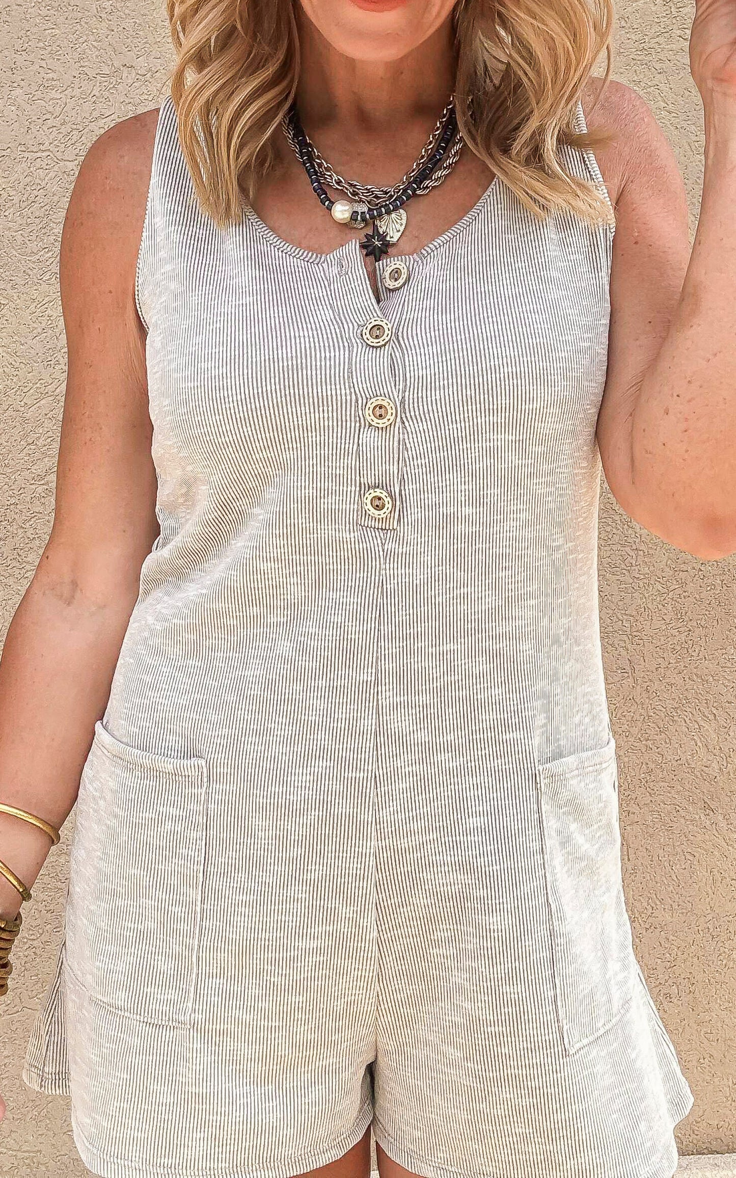 Close-up of a lightweight summer romper with a scoop neckline, button placket, and casual front pockets