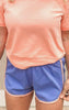 Sporty blue knit shorts with contrast orange piping and relaxed fit.