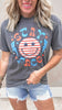 Patriotic smiley face graphic tee with red, white, and blue lettering.