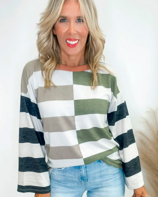 Woman wearing a striped colorblock sweater with a white background
