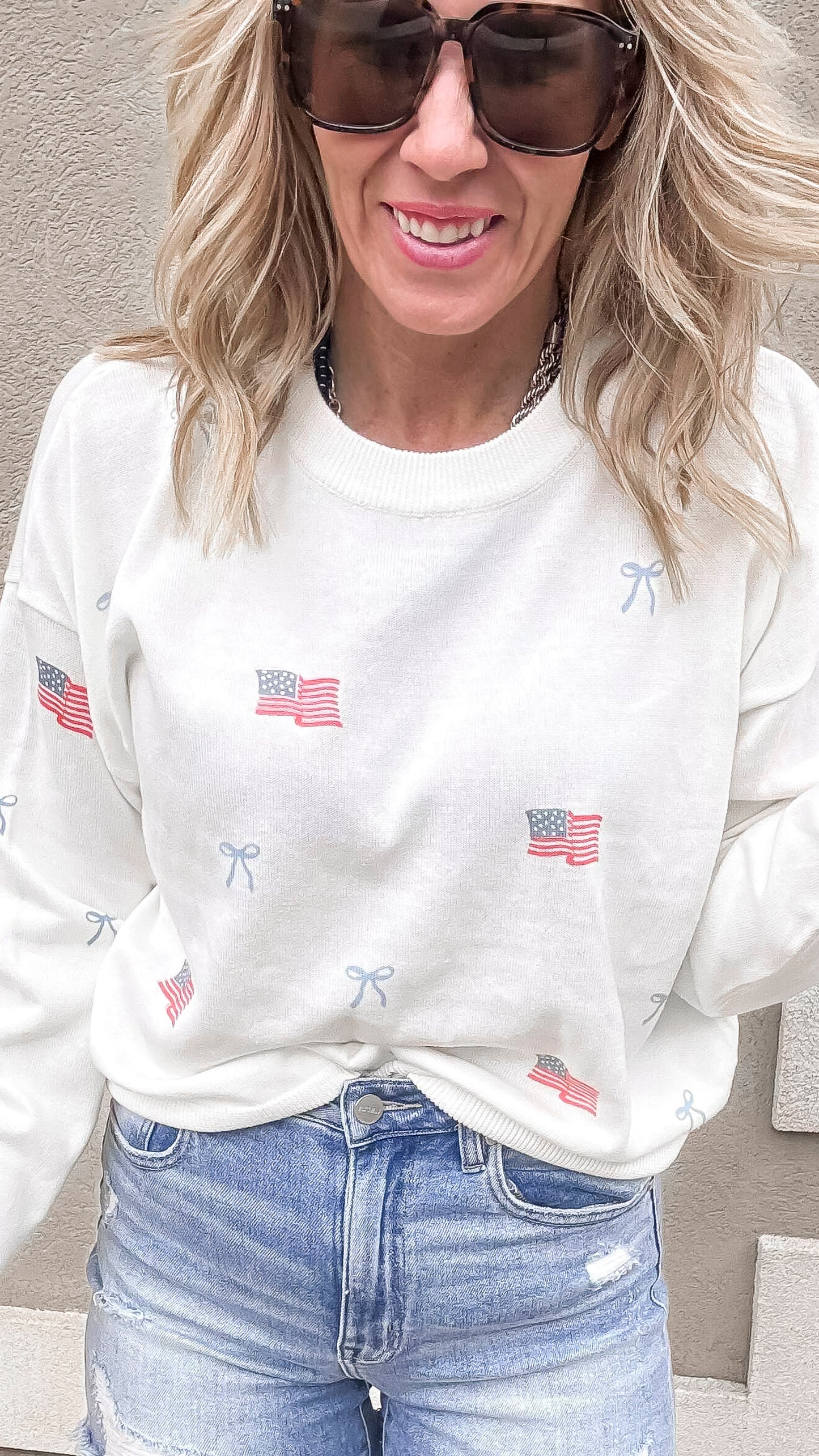 White USA flag and bows sweater paired with distressed denim shorts.