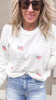 White USA flag and bows sweater paired with distressed denim shorts.