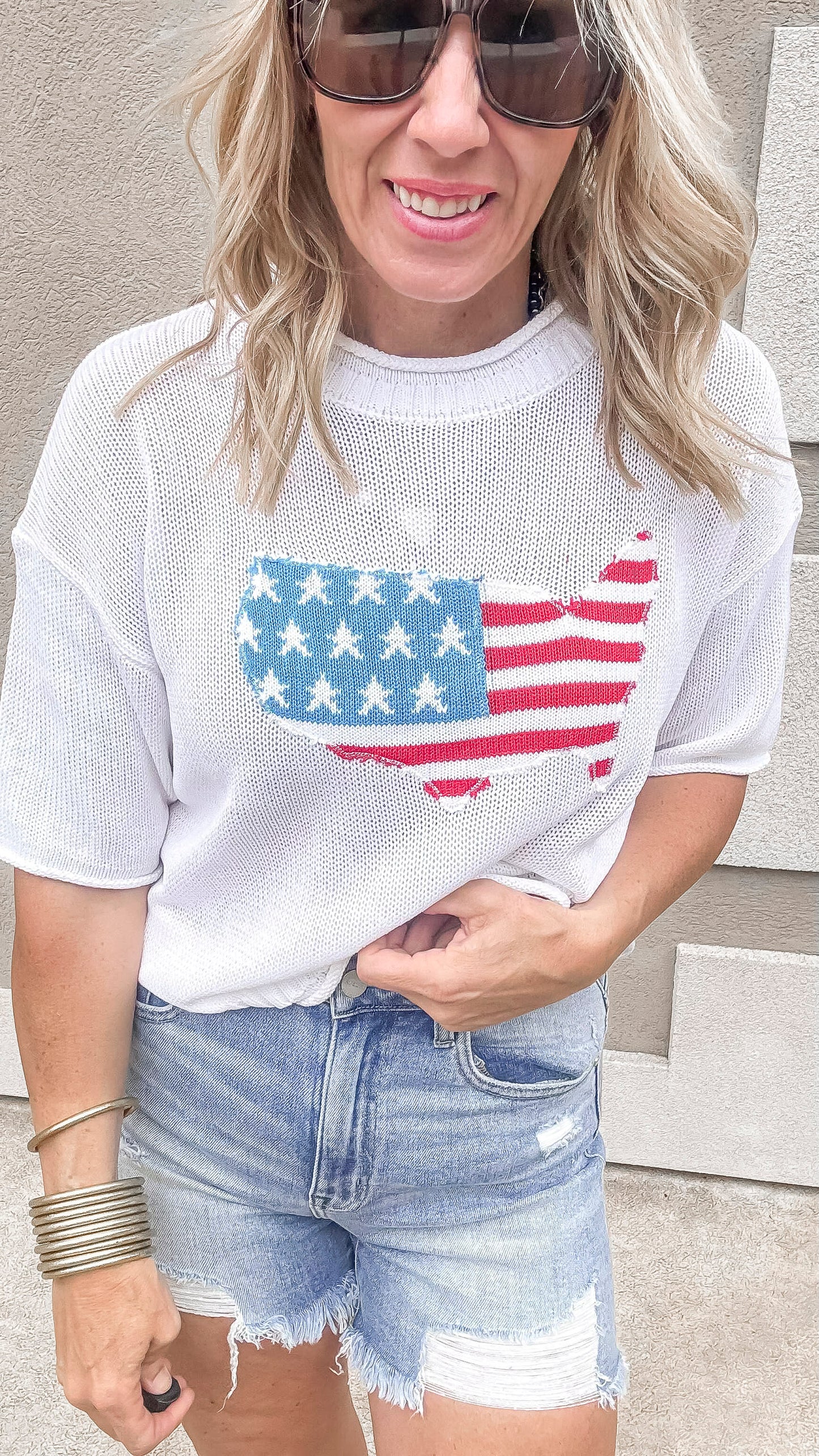 USA flag graphic sweater styled with distressed denim shorts.