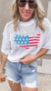 Patriotic flag print sweater paired with frayed denim cutoffs.