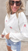 Cute white sweater with American flag and bows, worn with denim shorts.