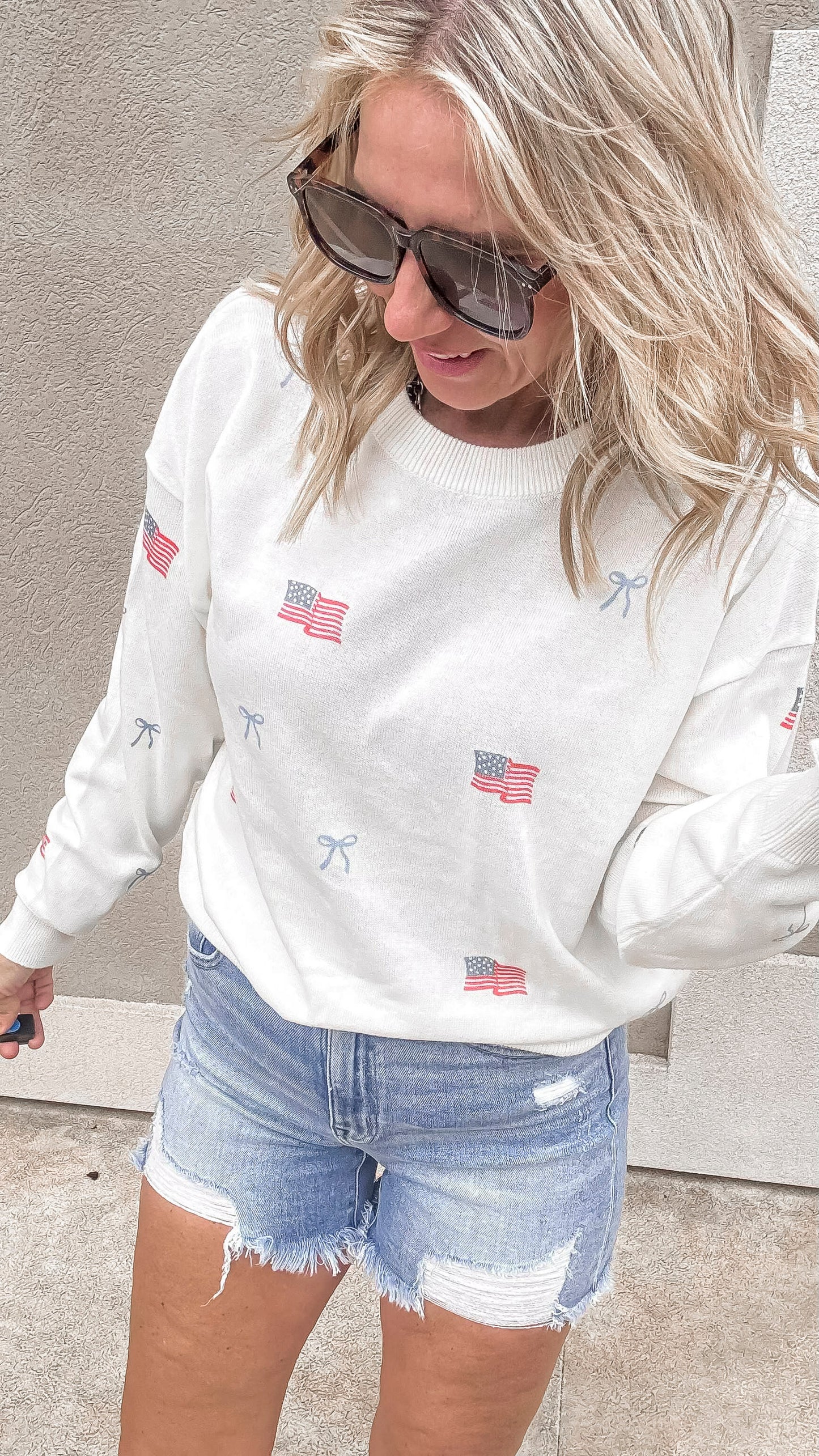 Patriotic crew neck sweater with flag and bows design and jean shorts.