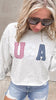 Patriotic USA sweatshirt paired with distressed denim shorts.