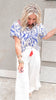 Wanderlust smocked top with blue and white print and tassel tie detail.