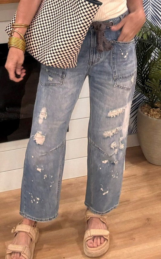 Distressed denim jeans with drawstring waist styled with a classic white tank.