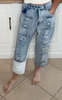 Distressed patchwork jeans with a cropped length and edgy street style.