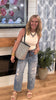 Casual washed jeans featuring ripped details and elastic waist paired with a ribbed white tank.