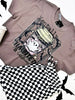 Gray t-shirt with graphic design featuring a coffee cup and text that says "Mentally Haunted and Caffinated", placed on a white surface.