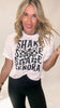 Woman wearing a white t-shirt with text and graphics on a plain background
