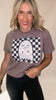 Woman wearing a brown t-shirt with a ghost graphic on a beige background