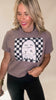 Woman wearing a brown t-shirt with a ghost design on a checkered background