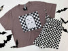 Gray t-shirt with ghost design and checkered shorts on a white background with black bats.
