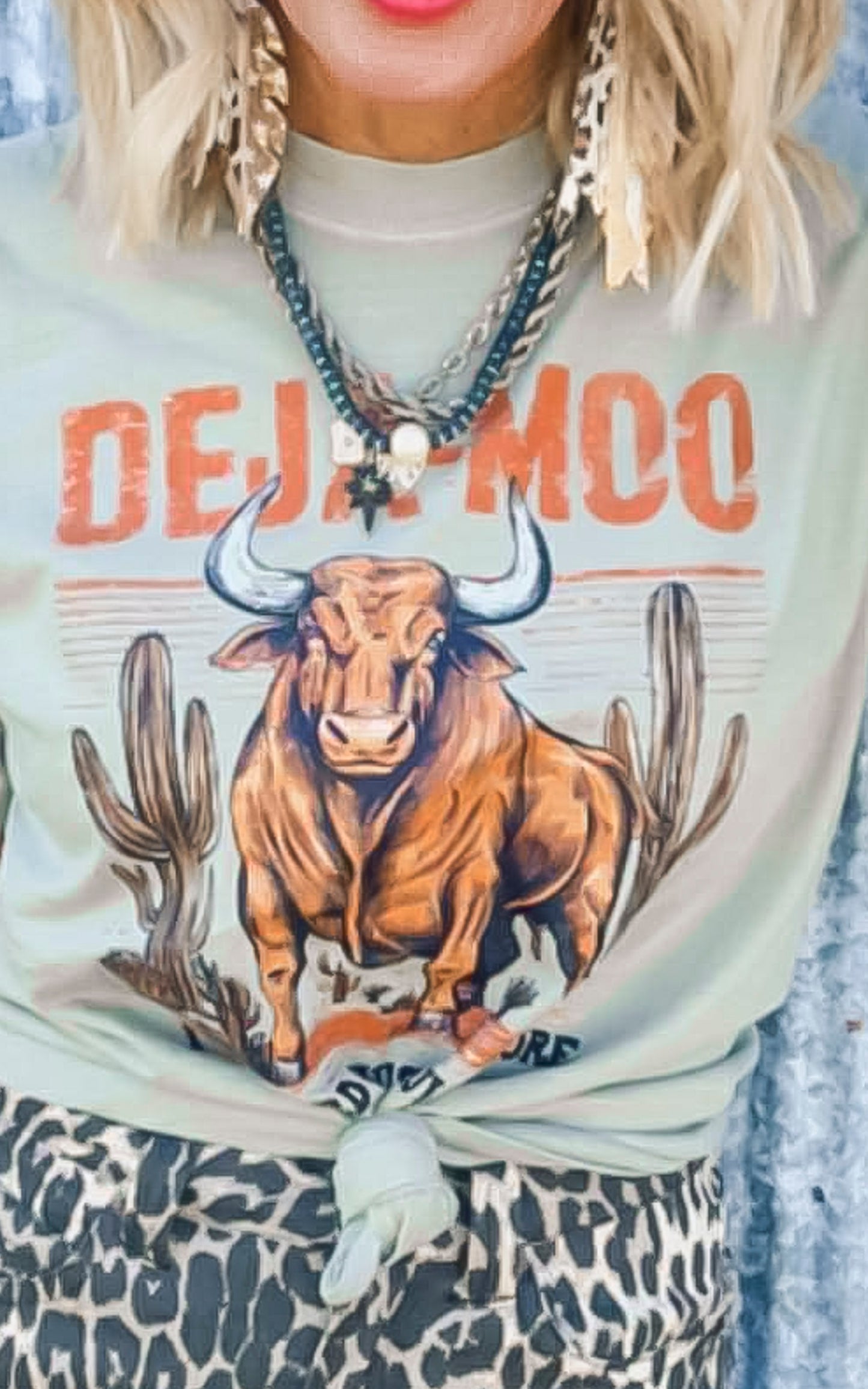 Person wearing a shirt with a bull graphic and 'DEJA MOO' text.