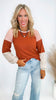 Woman wearing a brown and white checkered top with light blue jeans on a white background