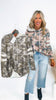Woman holding a camouflage hoodie with a matching jacket on a white background