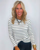 Woman wearing a striped long-sleeve top against a plain background