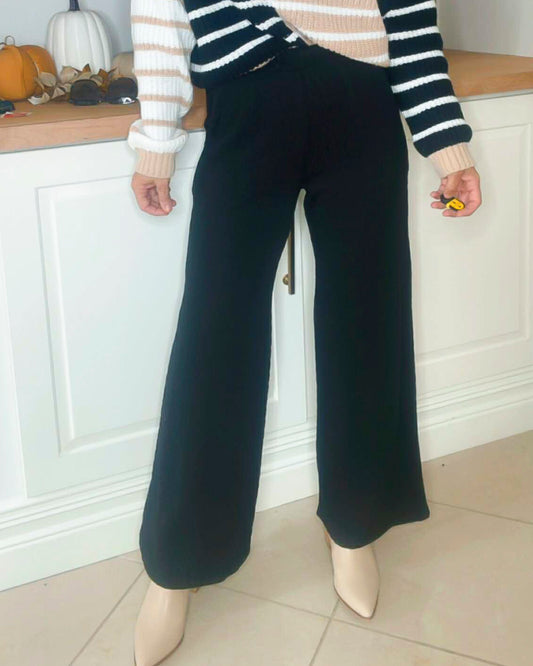 Person wearing black wide-leg pants in a kitchen setting