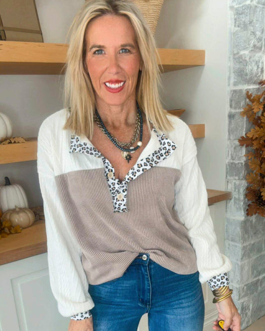 Woman wearing a patterned blouse with a neutral background