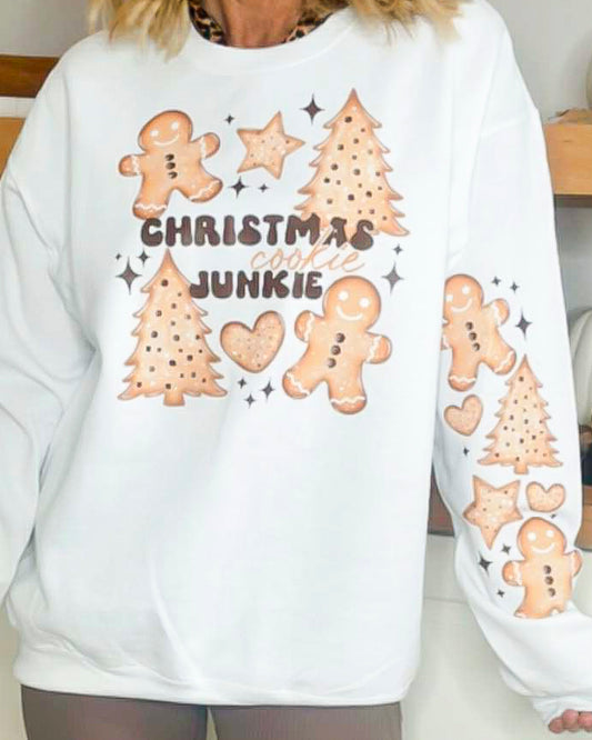 White sweatshirt with Christmas-themed graphics and text worn by a person.