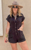 Casual black romper featuring cuffed sleeves, front buttons, and easy style.