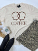 Beige t-shirt with 'COFFEE' design, Starbucks cup, and leopard print item on a light blue background
