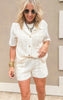Lacy knit set with wooden button-down top and drawstring shorts in soft cream.
